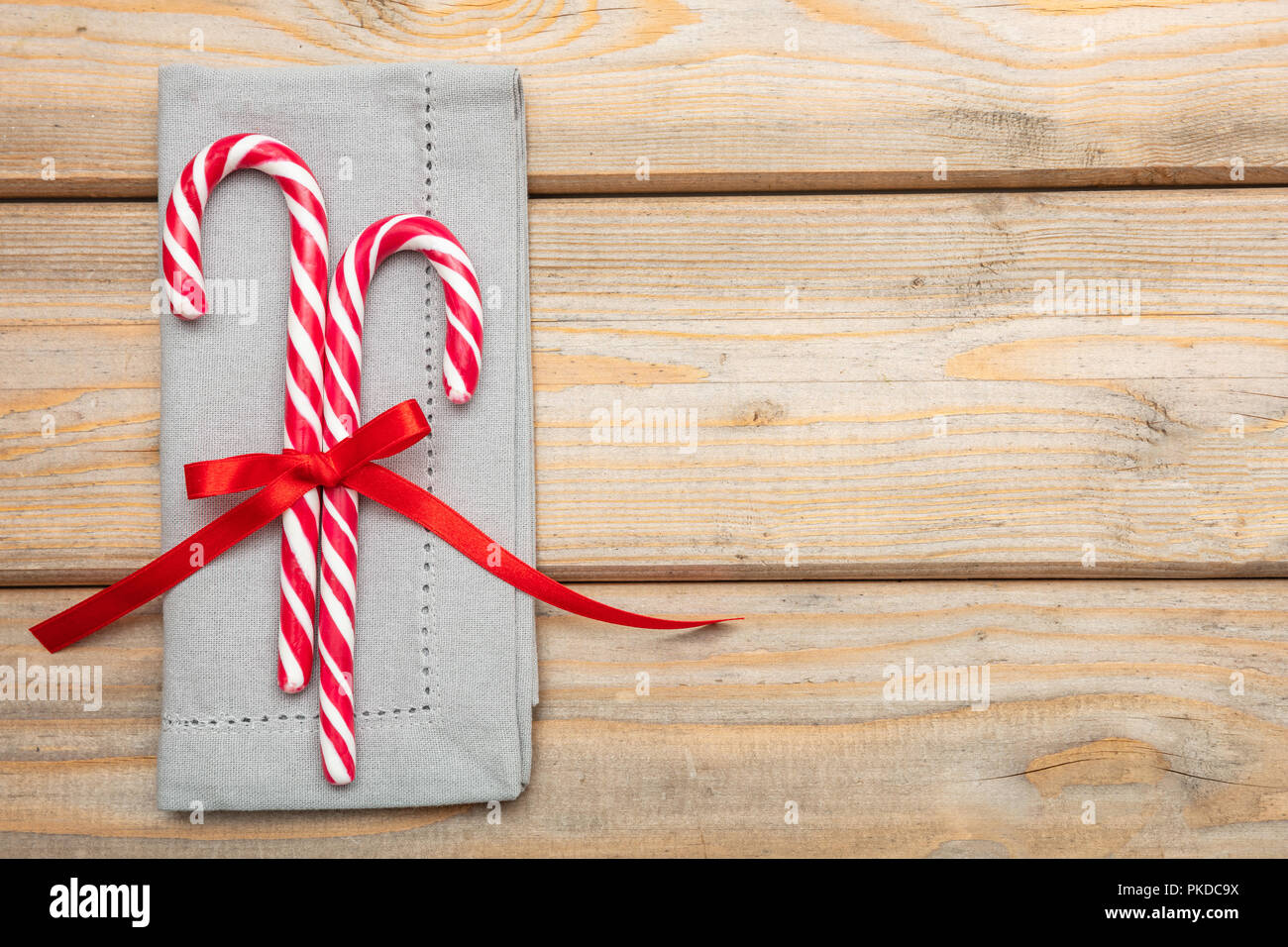 Christmas table setting. Candy canes with a red satin ribbon and a grey ...