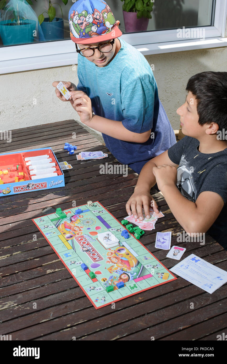 Young boys,10 years old play monopoly board game,UK Stock Photo