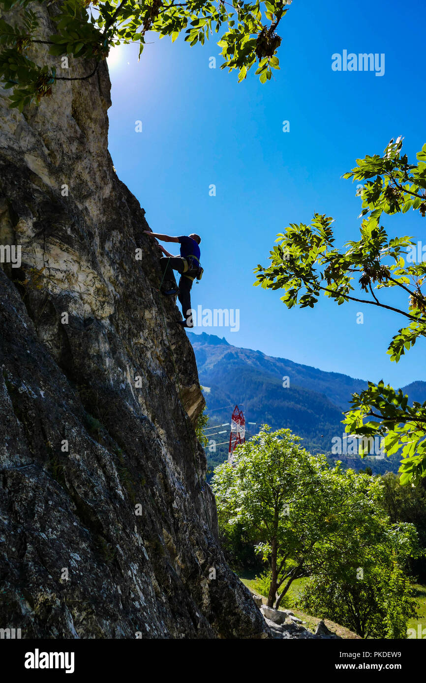 Mature male rock climber, silhouette, on rock face, Maurienne valley France Stock Photo