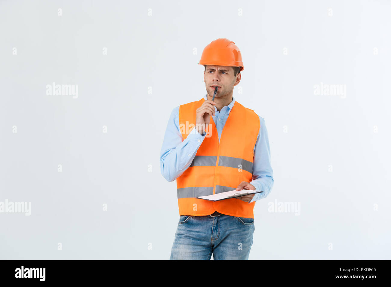 Portrait of Serious architect or engineer writing or taking notes on a clipboard isolated on white background Stock Photo