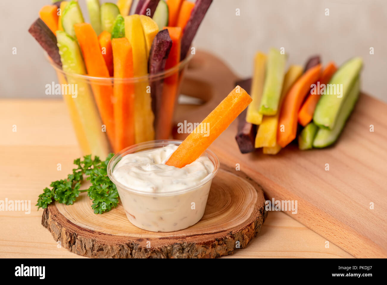colorful carrots and cucumbers julienne mixed and sour cream dip on wooden board, concept of healthy eating Stock Photo