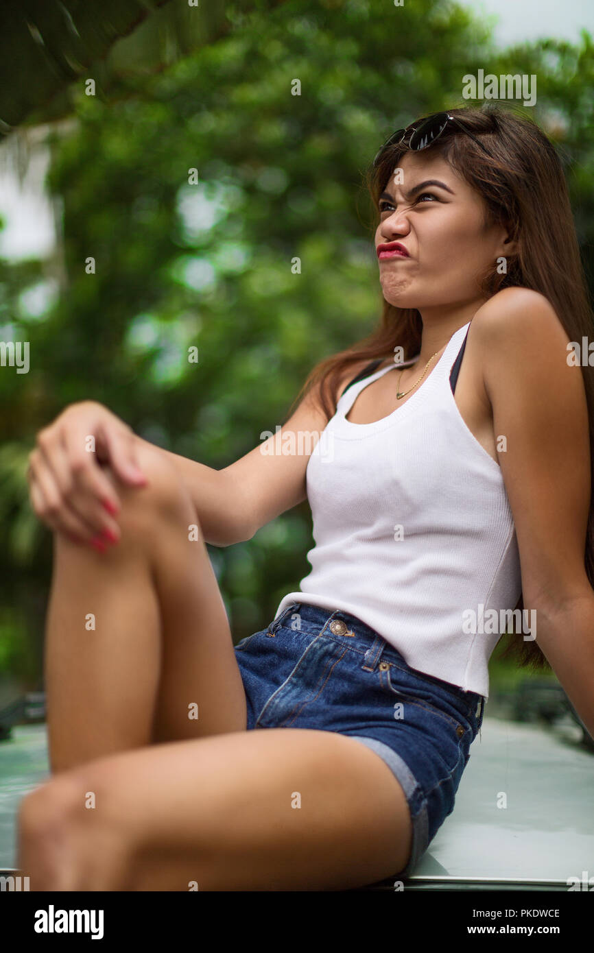 Beauty cool girl sitting posing on a car, reflection in glass windshield  Stock Photo - Alamy