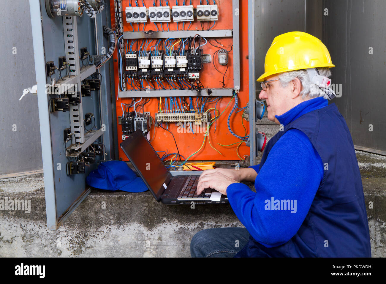 electrician at work with an electric panel Stock Photo