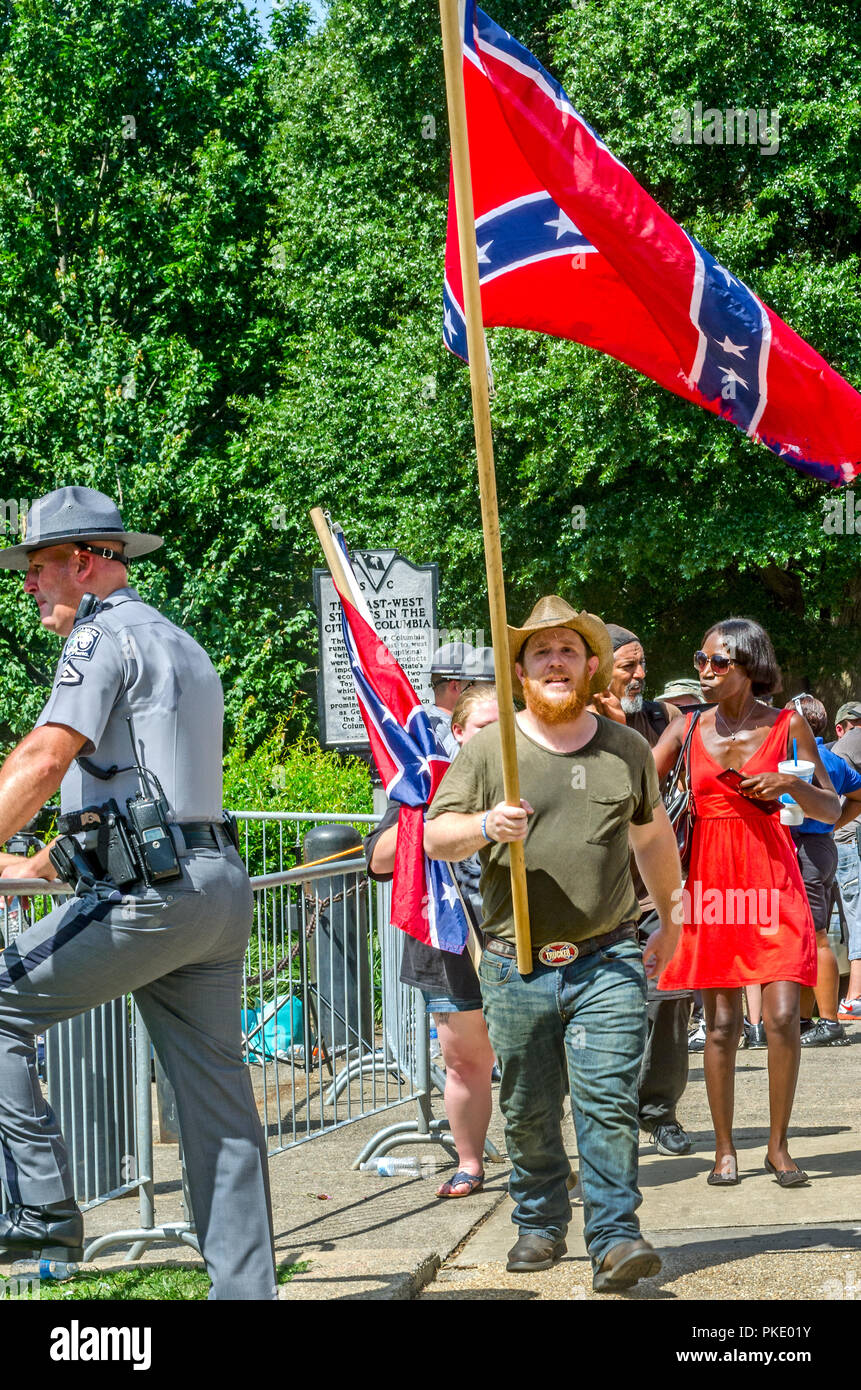 A man carries a Confederate flag outside the South Carolina State House to protest the flag's removal, July 10, 2015, in Columbia, South Carolina. Stock Photo
