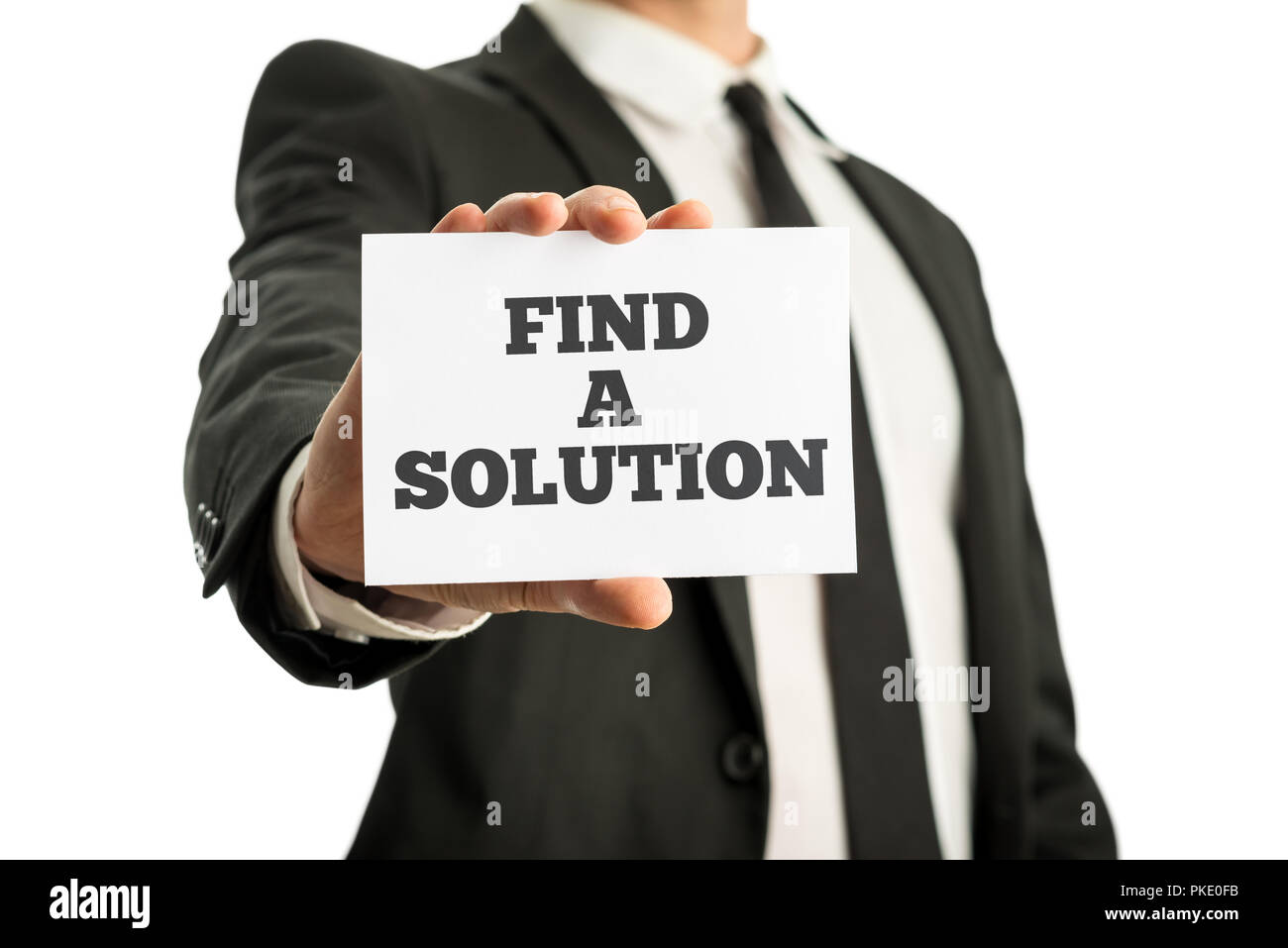 Business executive in a suit holding up a business card saying - Find a solution-, encouraging his team to make the best possible effort to satisfy th Stock Photo