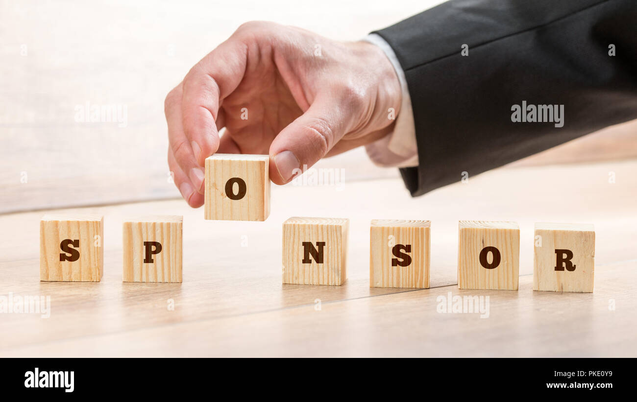 Close up Hand of a Businessman Arranging Small Wooden Blocks on the Table for Business Sponsor and Scholarship Concept. Stock Photo