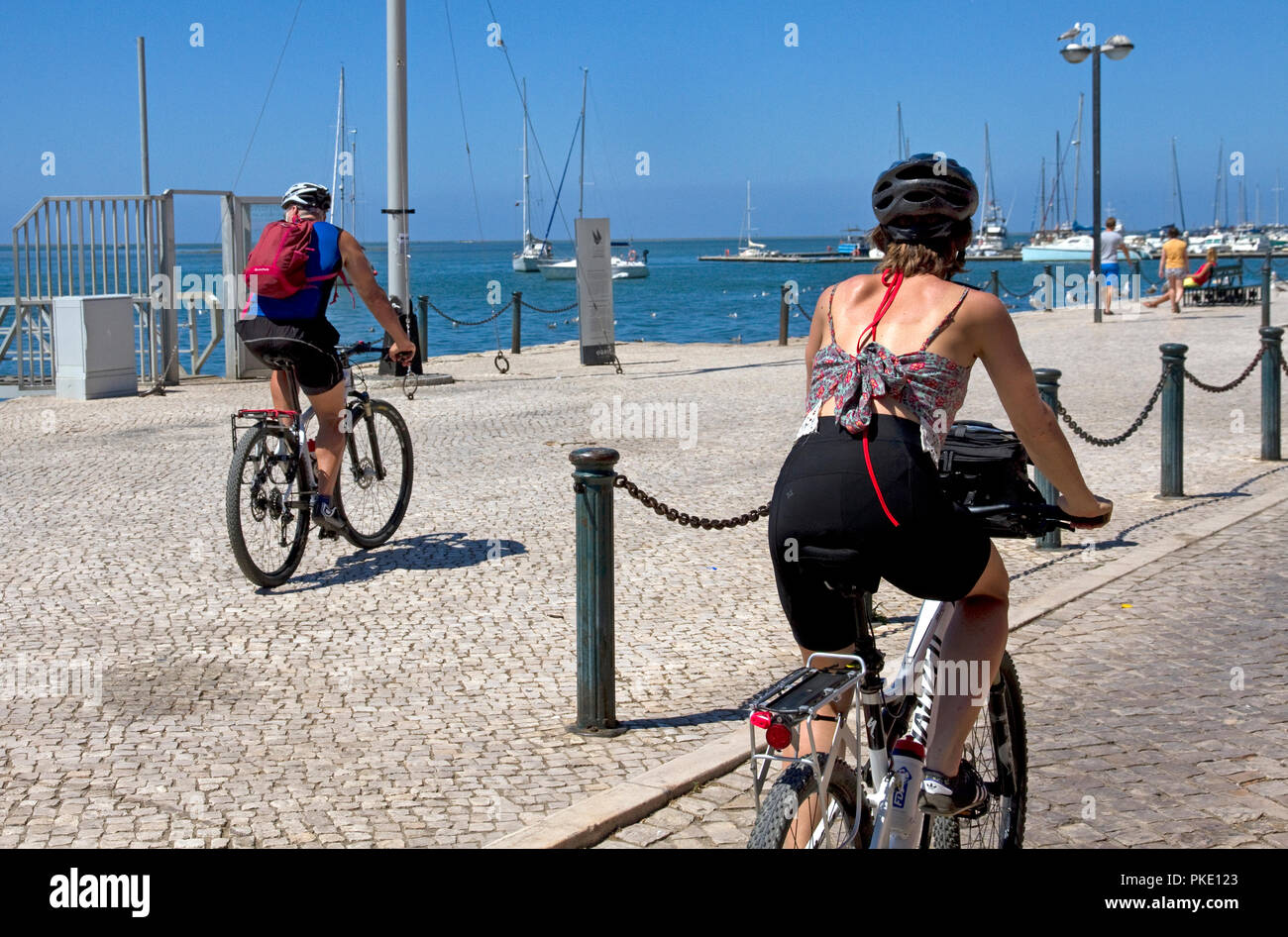 Cyclists on waterfront promenade. Olhao, Algarve, Portugal Stock Photo