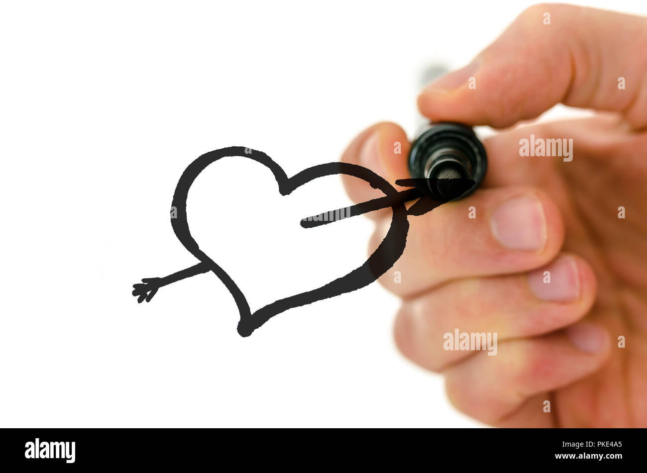 Detail of male hand drawing heart shape pierced with sharpe arrow on a ...
