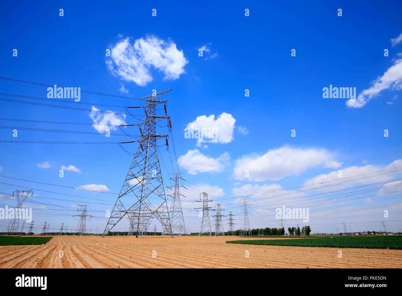 High voltage towers, under the blue sky white clouds Stock Photo - Alamy