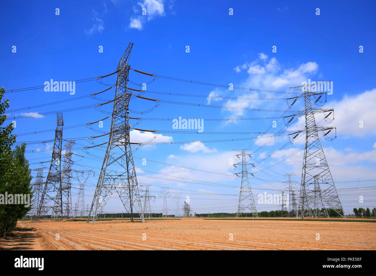 High voltage towers, under the blue sky white clouds Stock Photo - Alamy