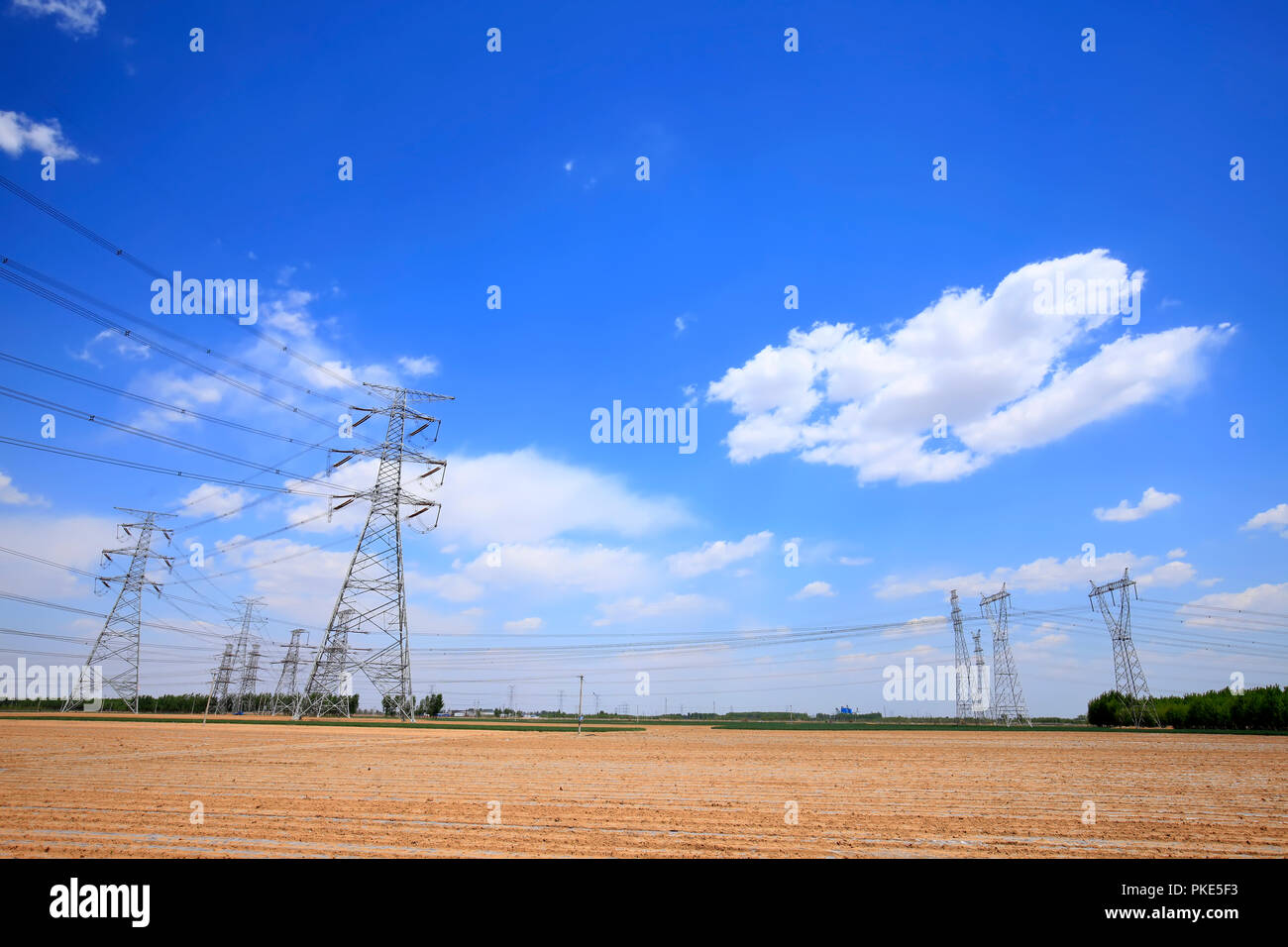 High voltage towers, under the blue sky white clouds Stock Photo - Alamy