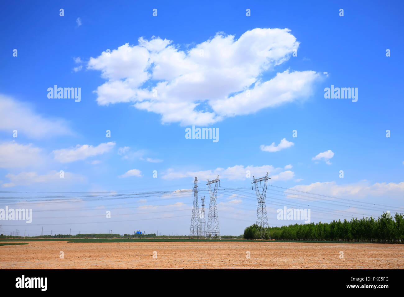 High voltage towers, under the blue sky white clouds Stock Photo - Alamy