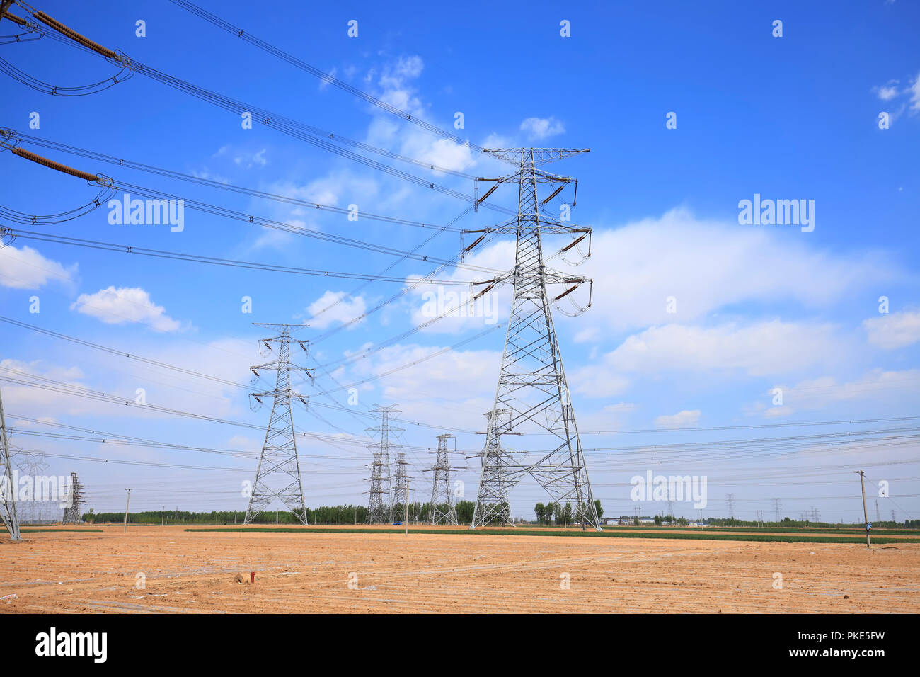 High voltage towers, under the blue sky white clouds Stock Photo - Alamy