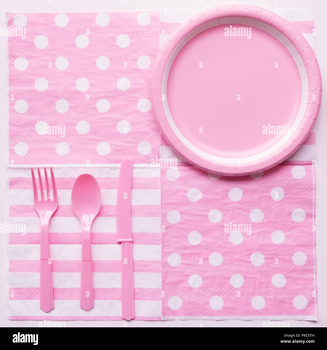 Pink color paper plate with plastic spoon, fork and knife Stock Photo