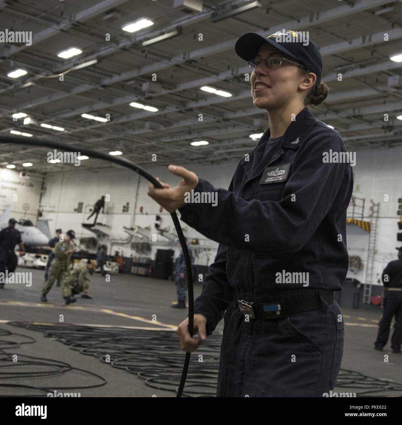 NORFOLK, Va. (July 25, 2018) Interior Communications Electrician 3rd Class Louise Atticks, from Harrisburg, Pennsylvania, coils plain old telephone system (POTS) lines during cleaning stations aboard the aircraft carrier USS George H.W. Bush (CVN 77). The ship is in port in Norfolk, Virginia, conducting routine training exercises to maintain carrier readiness. Stock Photo
