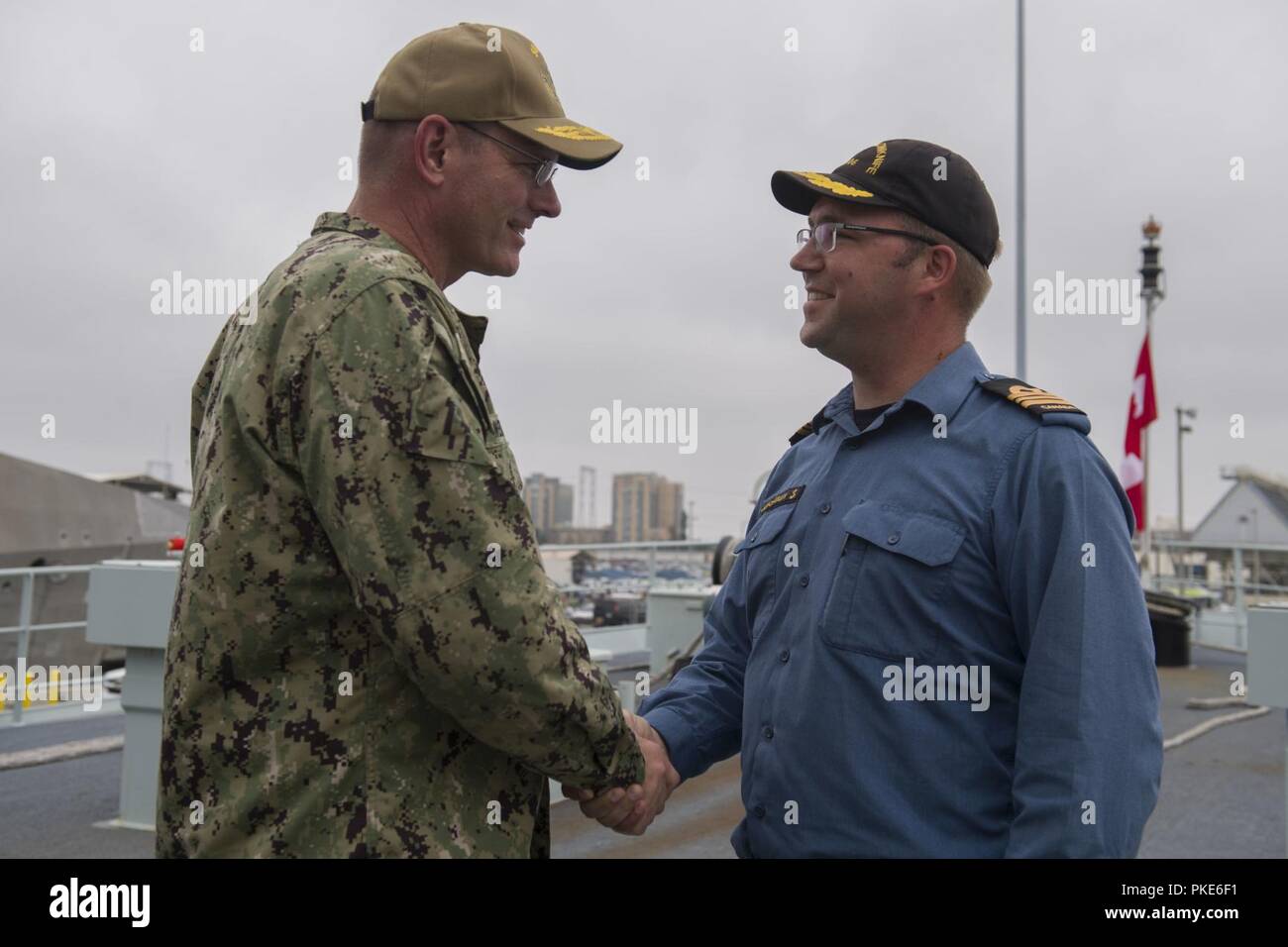 SAN DIEGO (July 26, 2018) Rear Adm. Dave Welch, commander, Task Force 177, Naval Surface and Mine Warfighting Development Center (SMWDC), is greeted by  Lt. Cmdr. Donald Thompson-Greiff, commanding officer of the Royal Canadian Navy coastal defense vessel HMCS Yellowknife (MM 706), during a visit to the ship in support of Rim of the Pacific (RIMPAC) exercise, July 26. Twenty-five nations, 46 ships, five submarines, about 200 aircraft and 25,000 personnel are participating in RIMPAC from June 27 to Aug. 2 in and around the Hawaiian Islands and Southern California. The world’s largest internatio Stock Photo