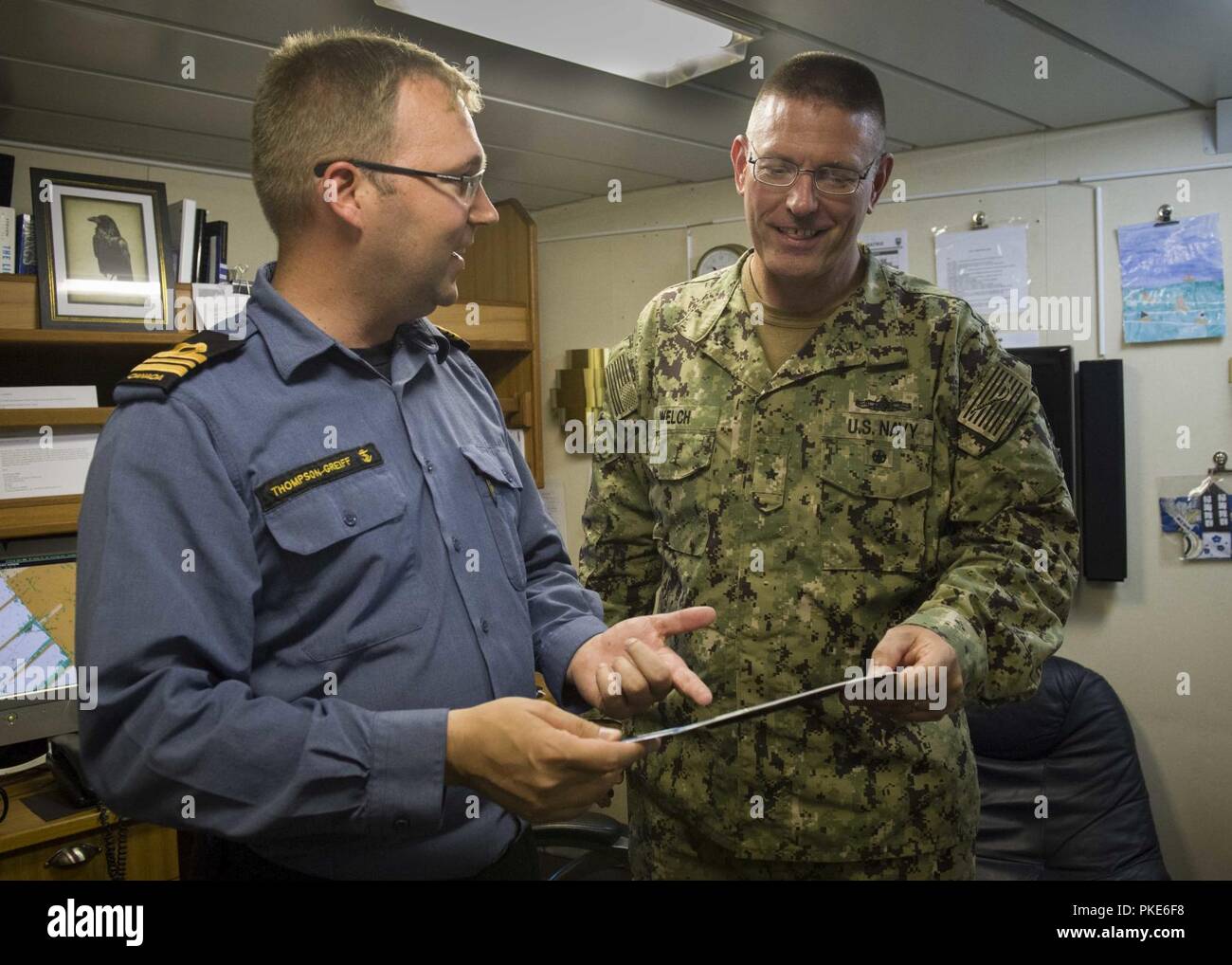 SAN DIEGO (July 26, 2018) Lt. Cmdr. Donald Thompson-Greiff, commanding officer of the Royal Canadian Navy coastal defense vessel HMCS Yellowknife (MM 706), shows Rear Adm. Dave Welch, commander, Task Force 177, Naval Surface and Mine Warfighting Development Center (SMWDC), a license plate for the ship, gifted by the city of Yellowknife, during his visit to the ship in support of the Rim of the Pacific (RIMPAC) exercise, July 26. Twenty-five nations, 46 ships, five submarines, about 200 aircraft and 25,000 personnel are participating in RIMPAC from June 27 to Aug. 2 in and around the Hawaiian I Stock Photo
