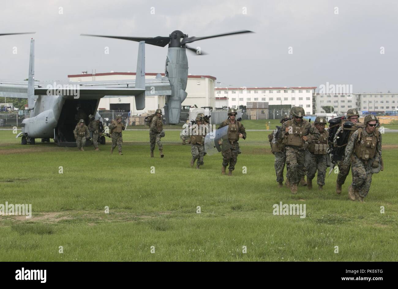 Marines with Fox Battery, Battalion Landing Team, 2nd Battalion, 5th Marines, exit an MV-22B Osprey during on-off drills at Camp Hansen, Okinawa, Japan, July, 26, 2018. Fox Battery Marines provide a precision fire capability as the artillery element attached to BLT 2/5 the Ground Combat Element for the 31st Marine Expeditionary Unit. The Osprey belongs to Marine Medium Tiltrotor Squadron 262 (Reinforced), the aviation combat element for the 31st MEU. The 31st MEU, the Marine Corps’ only continuously forward-deployed MEU, provides a flexible force ready to perform a wide-range of military opera Stock Photo