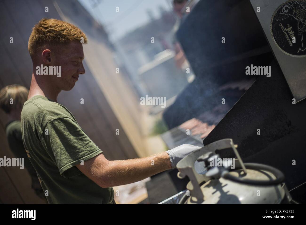 U.S. Marine Lance Cpl. Andrew Hendricks, an ammunition technician with 1st Supply Battalion, Combat Logistics Regiment 15, 1st Marine Logistics Group, cooks hamburgers during a family day event at Camp Pendleton, Calif., July 26, 2018. During family day, Marines and Sailors are encouraged to bring their families out for a day of events and fun to build camaraderie and unit cohesion. Stock Photo