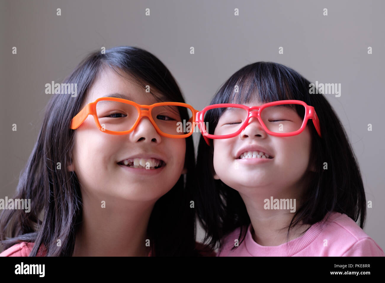 Two little sisters with big eyeglasses Stock Photo