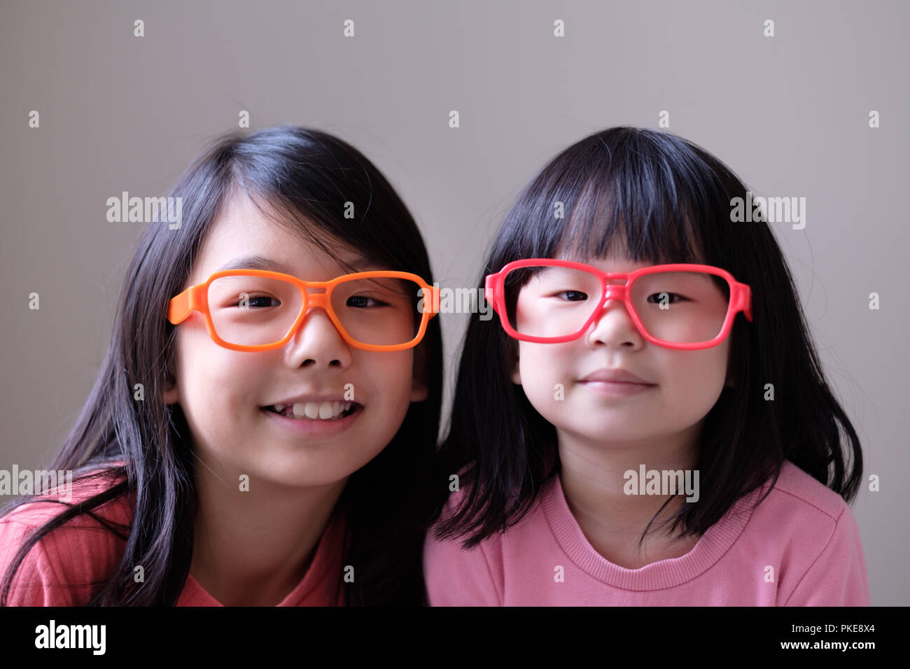 Two little sisters with big eyeglasses Stock Photo