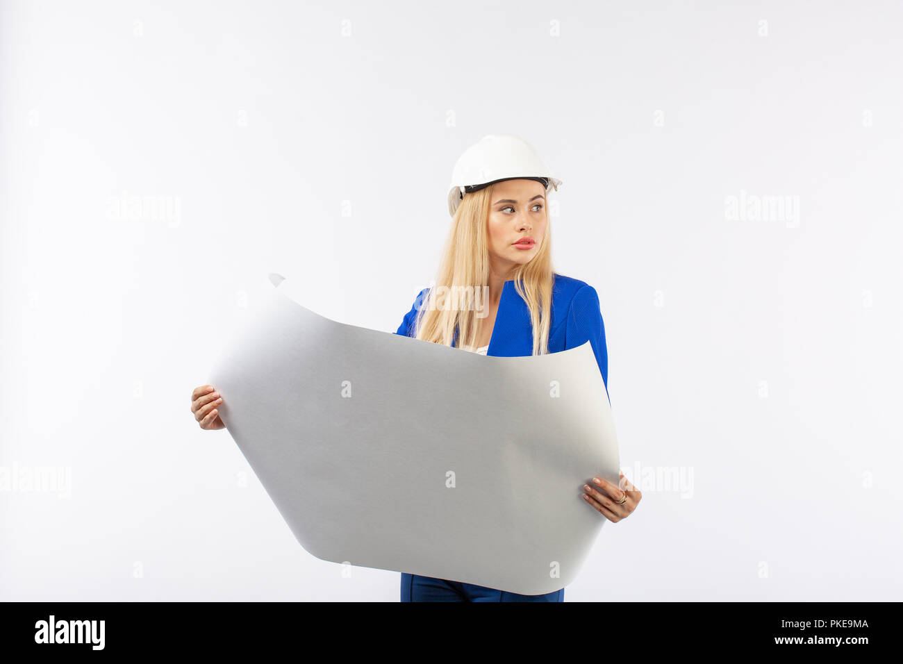 Employee woman in suit standing in helmet with paper documents on white ...