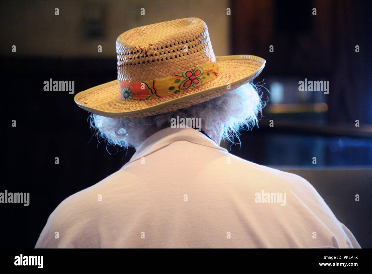 Old man who is standing alone in a real straw hat with white hair and is in his 90's, out for lunch by himself after wife's death Stock Photo