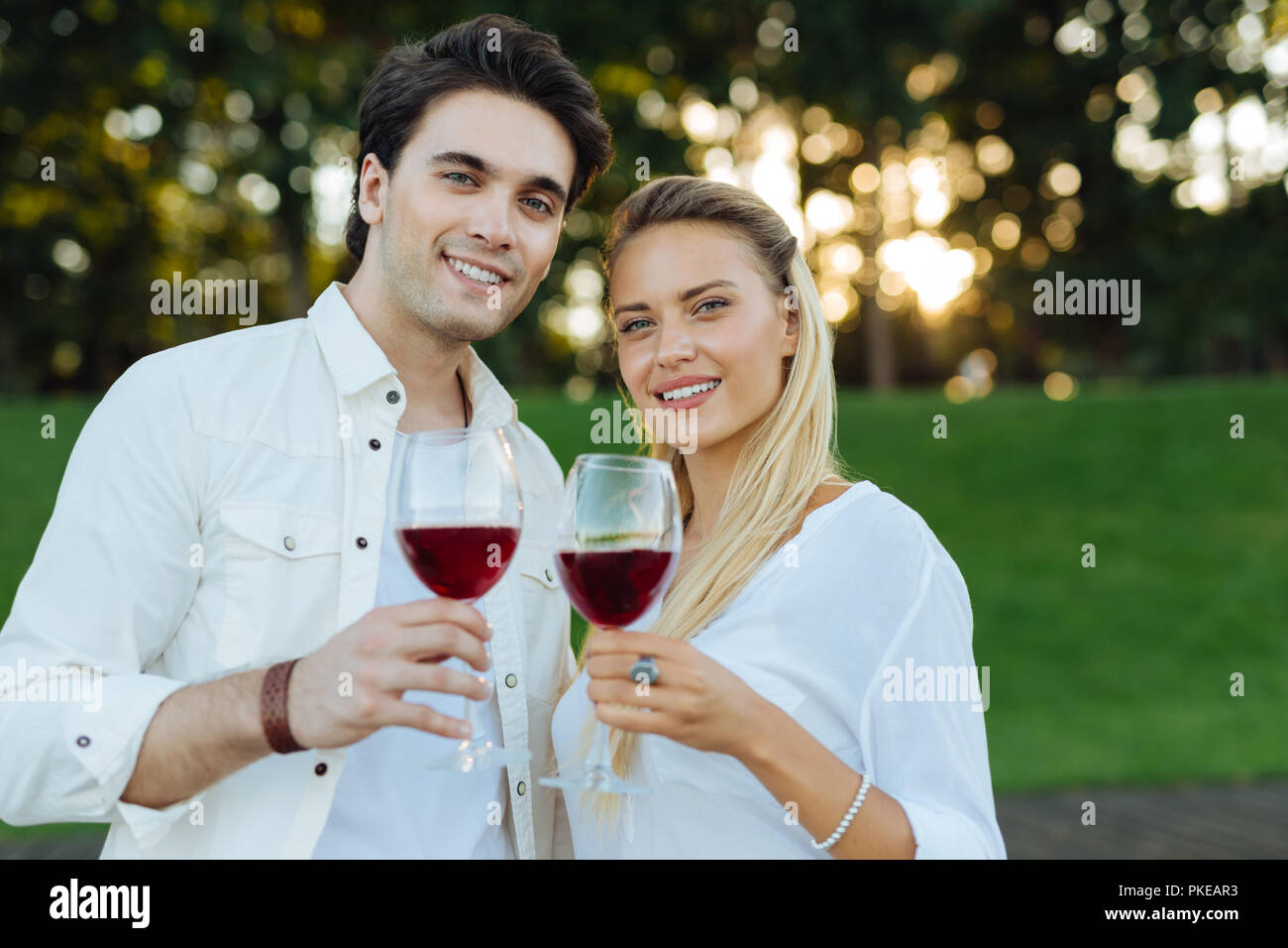 Happy nice young couple drinking red wine together Stock Photo - Alamy