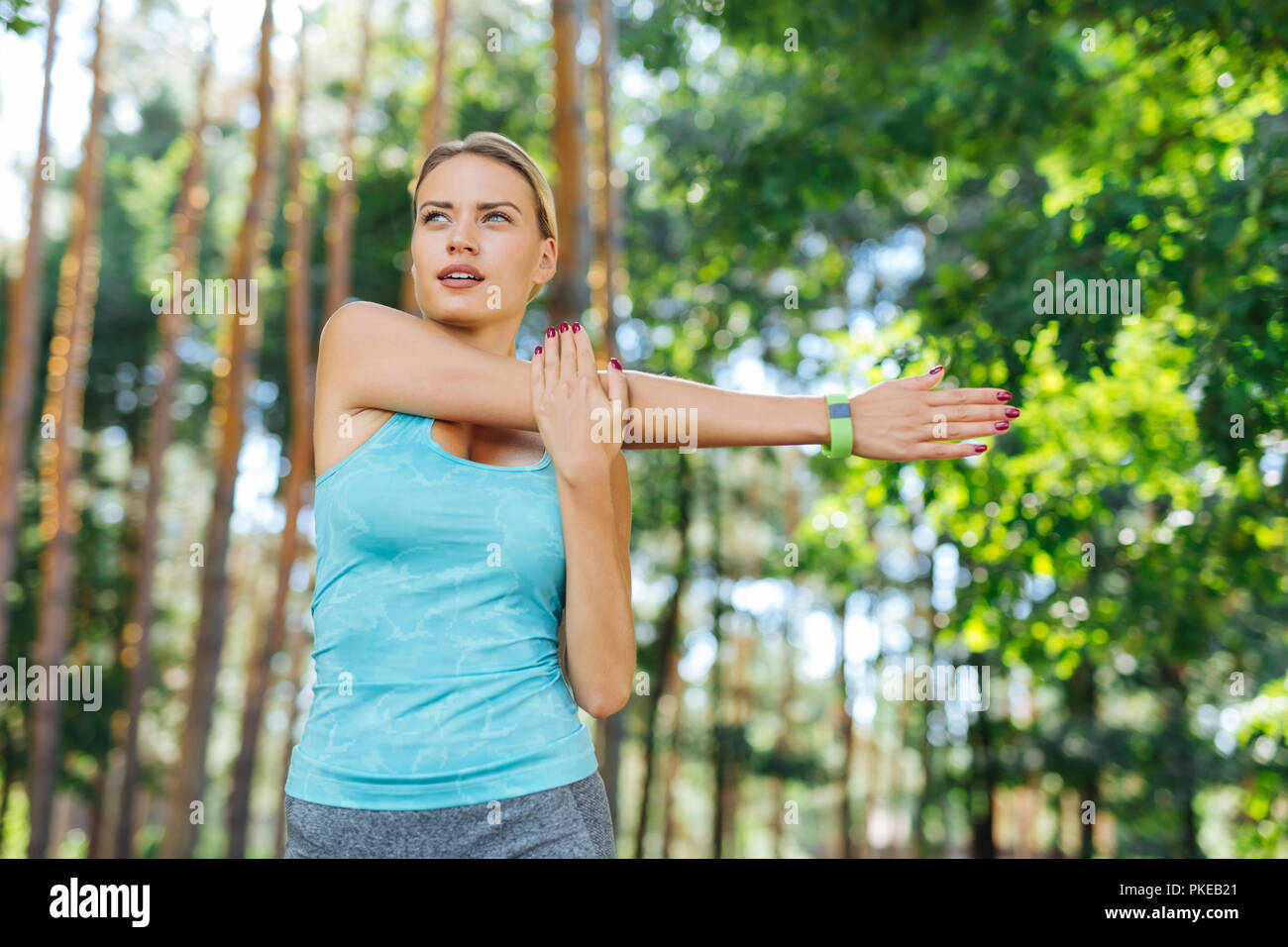 Serious sporty young woman moving her hand Stock Photo