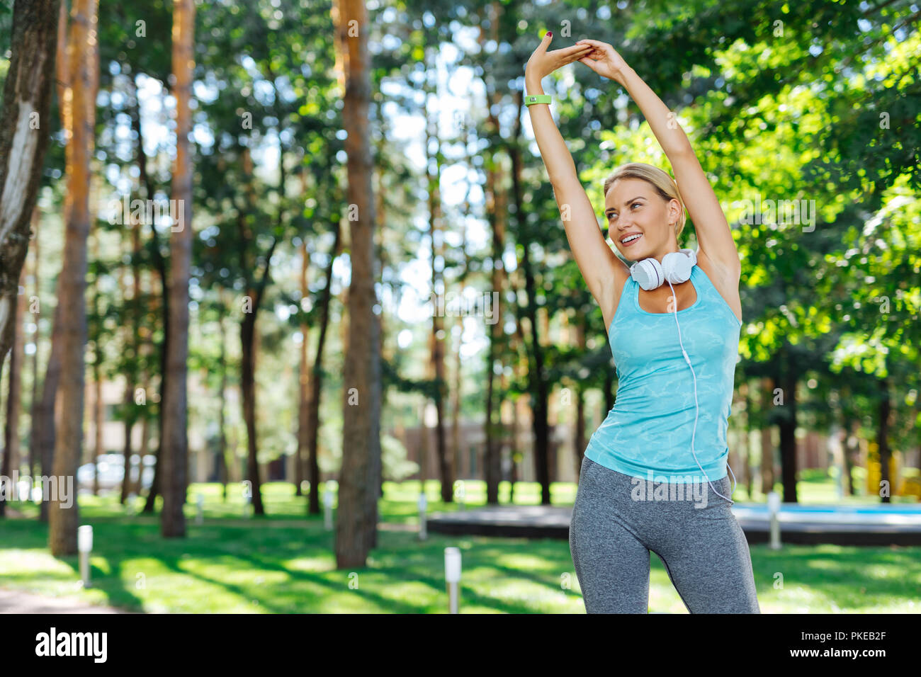 Joyful young woman exercising alone in the park Stock Photo