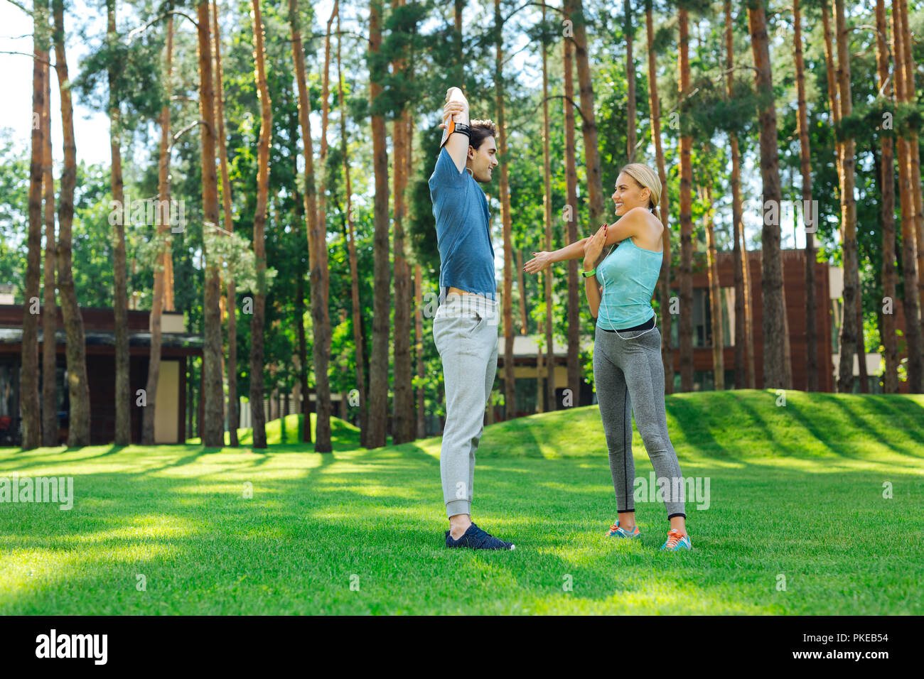 Positive young couple doing morning gymnastics exercises Stock Photo