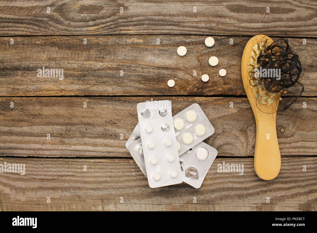 Fallen hair on comb and pill Stock Photo