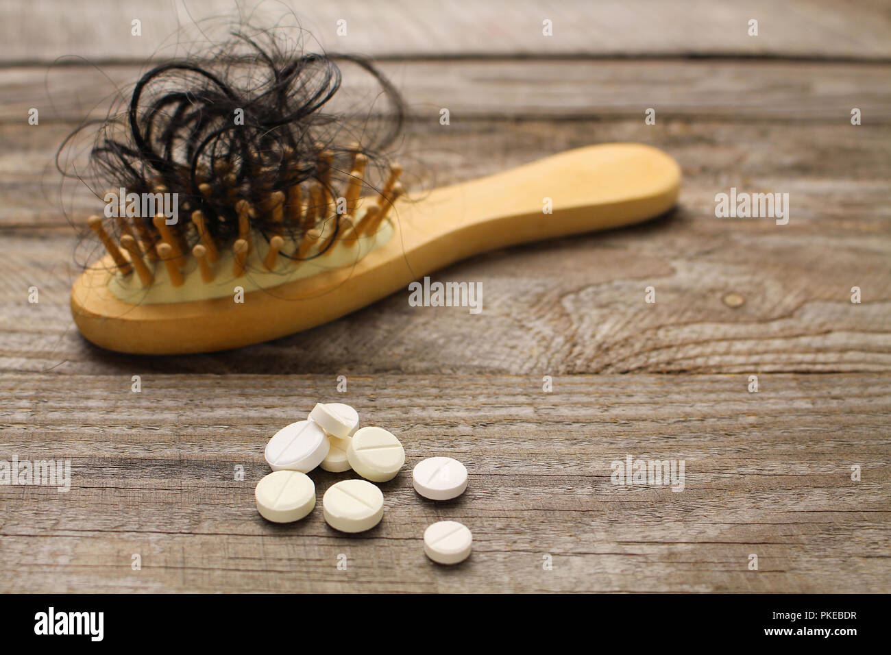 Fallen hair on comb and pill Stock Photo