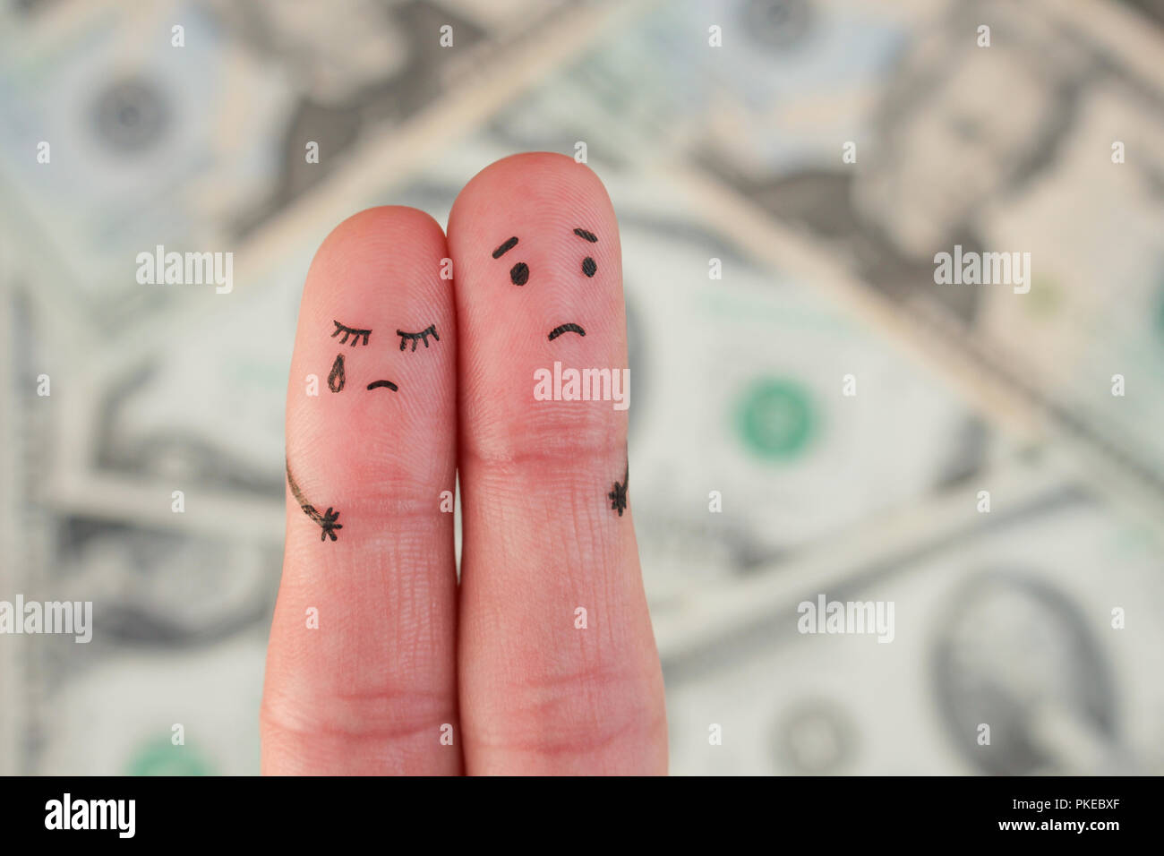 Fingers art of displeased couple on background of money. Concept of poor people. Stock Photo