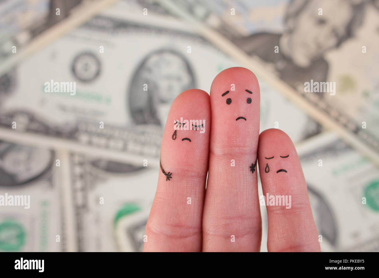 Finger art of displeased family on background of money. Concept of poor people. Stock Photo