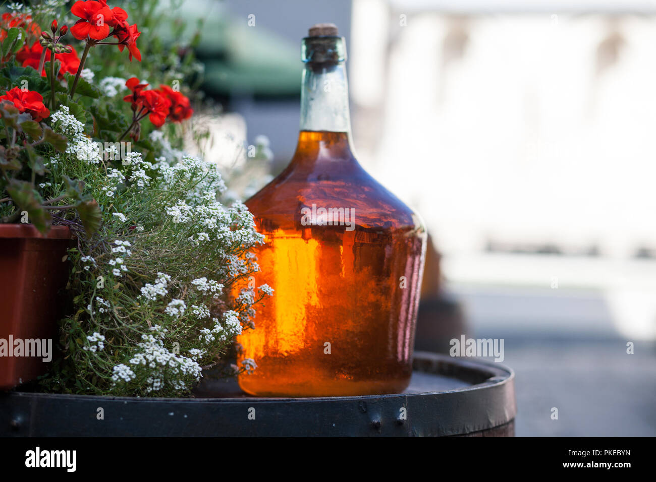 Large bottle of homemade wine are on the barrel. Vintage large wine