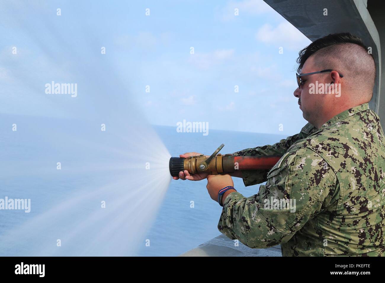 U.S. Navy Hospital Corpsman 3rd Class Christian Winey conducts hose handling training aboard the expeditionary fast transport vessel USNS Spearhead (T-EPF 1), July 27, 2018. Spearhead is at sea preparing to support Southern Partnership Station. Southern Partnership Station is a U.S. Southern Command-sponsored and U.S. Naval Forces Southern Command/U.S. 4th Fleet-conducted annual deployment focused on subject matter expert exchanges and building partner capacity in a variety of disciplines including medicine, construction and dive operations in the Caribbean, Central and South America. Stock Photo