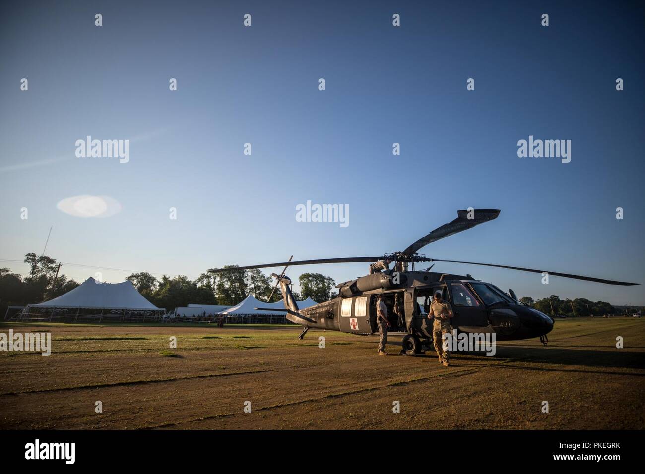 U.S. Army Soldiers assigned to 1-171st GSAB (Medevac), Rochester, N.Y., prepare a UH-60 Blackhawk before competition jumps begin during Leapfest at the University of Rhode Island, West Kingston, R.I., Aug. 5, 2018. Leapfest is the largest, longest standing, international static line parachute training event and competition hosted by the 56th Troop Command, Rhode Island Army National Guard to promote high level technical and esprit de corps within the International Airborne community. Stock Photo