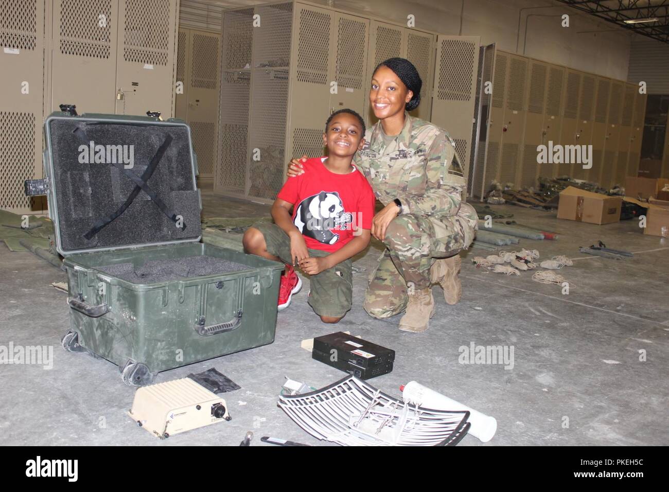 Sgt. Charnelle Carrington, petroleum supply noncommissioned officer, Company A, 123rd Brigade Support Battalion, 3rd Armored Brigade Combat Team, poses with her son at Company A’s company operations facility during Bring Your Child to Work Day July 27. Stock Photo