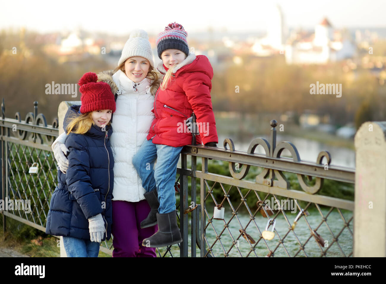 Young mother and her two daughters having fun on beautiful winter day in Vilnius. Spending time with family in winter. Stock Photo