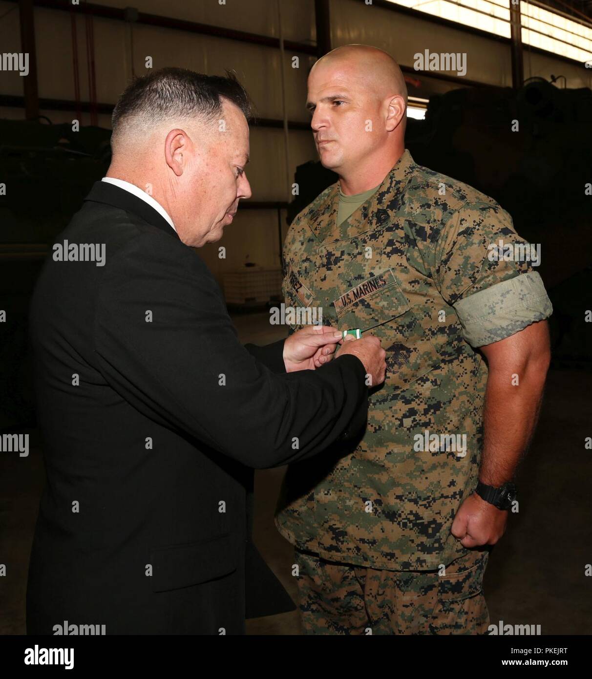 https://c8.alamy.com/comp/PKEJRT/gunnery-sgt-jeff-perez-tamn-lead-e-tamn-marine-force-storage-command-marine-corps-logistics-command-receives-a-navy-and-marine-corps-commendation-medal-from-retired-marine-lt-col-brian-spooner-retiring-official-during-a-retirement-ceremony-held-aboard-marine-corps-logistics-base-albany-aug-1-PKEJRT.jpg