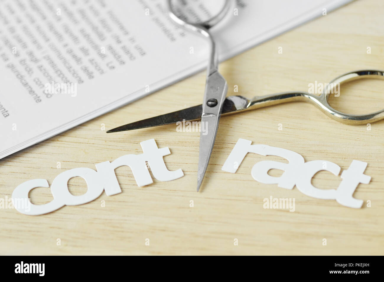 Scissors cutting the word Contract - Contract termination concept Stock Photo