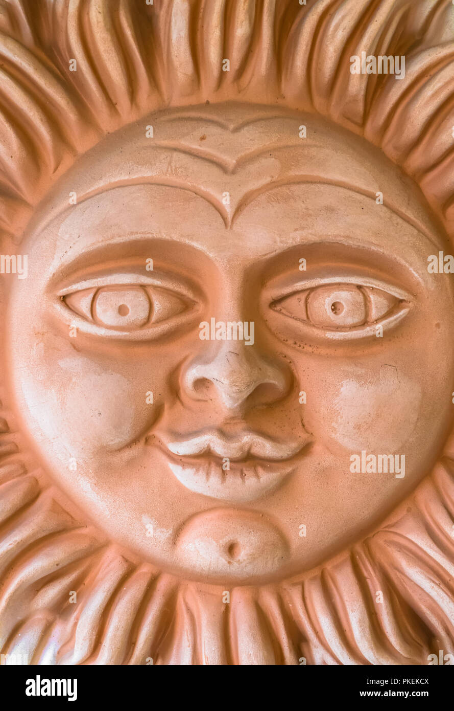 Clay sculpture depicting a smiling sun. It can be used as background. Stock Photo