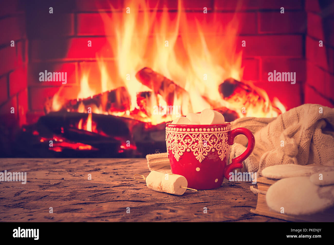https://c8.alamy.com/comp/PKENJY/mug-of-hot-chocolate-or-coffee-with-marshmallows-in-a-red-mug-on-vintage-wood-table-in-front-of-fireplace-as-a-background-christmas-or-winter-warming-PKENJY.jpg