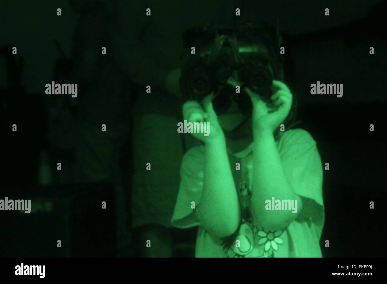 A daughter of a Soldier, assigned to 10th Special Forces Group (Airborne), navigates through a kids night vision goggle course during the Group’s family day on,Fort Carson, Colo., July 27, 2018. The Group’s family day is designed to bring Soldiers and families together to celebrate the unit and enjoy the afternoon. Stock Photo