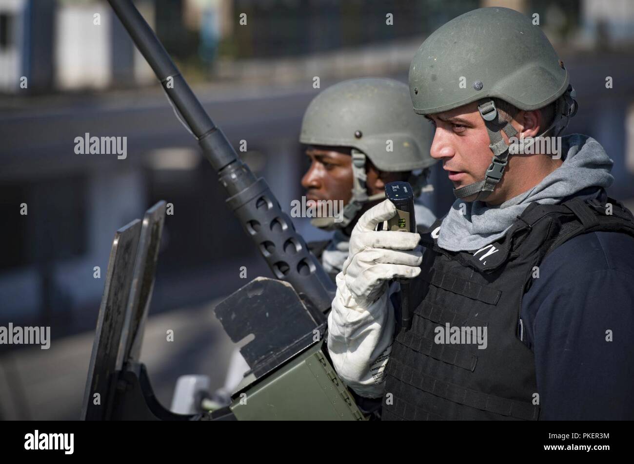 Algeria (July 31, 2018)  Fire Controlman 2nd Class Dalton Eiler, right, and Gunner’s Mate 2nd Class Jokenzie Broughton man a .50-caliber machine gun aboard the Arleigh Burke-class guided-missile destroyer USS Carney (DDG 64) as the ship departs Algiers, Algeria, following a scheduled port visit July 31, 2018. Carney, forward-deployed to Rota, Spain, is on its fifth patrol in the U.S. 6th Fleet area of operations in support of regional allies and partners as well as U.S. national security interests in Europe and Africa. Stock Photo