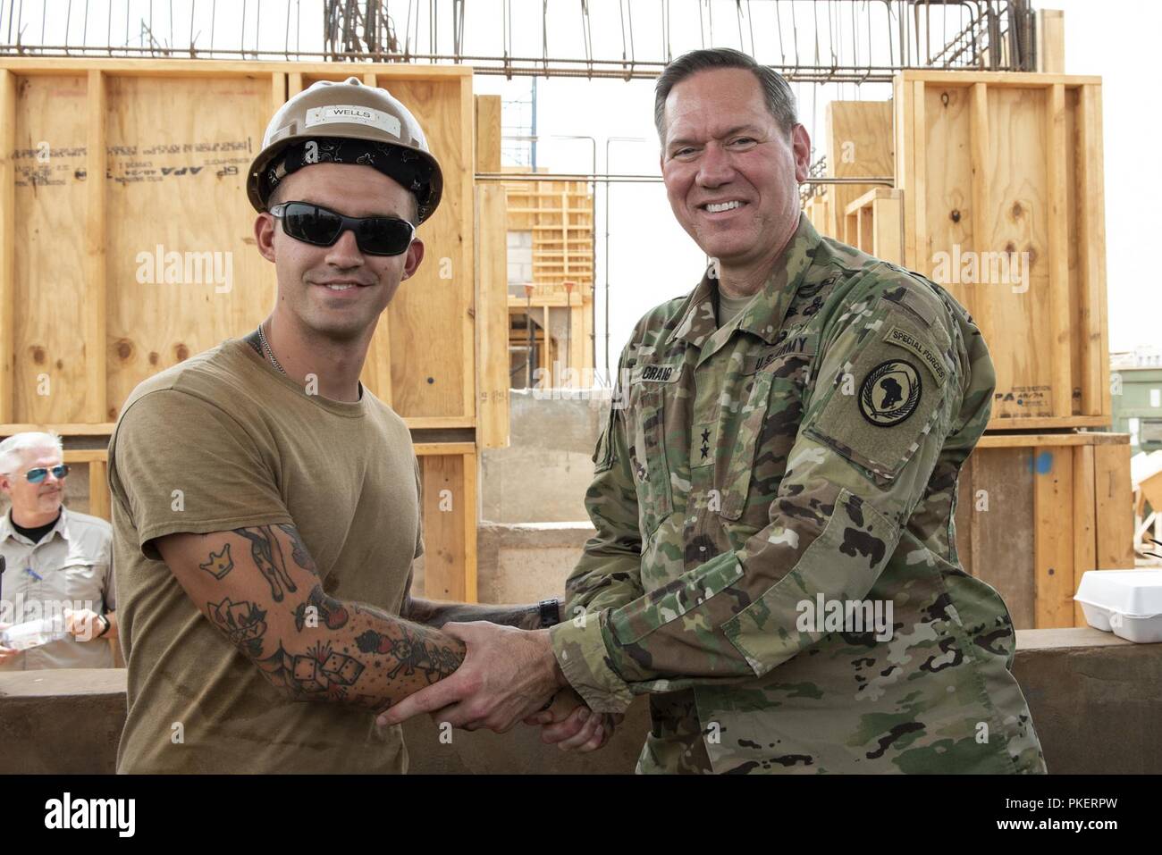 U.S. Navy Builder Constructionman Grant Wells, project crewmember, Naval Mobile Construction Battalion 11, Combined Joint Task Force - Horn of Africa, and U.S. Army Maj. Gen. James Craig, commanding general, CJTF-HOA, pose for a photo outside of Ali Oune, Djibouti, July 30, 2018. Wells was recognized for all of his hard work, positivity and work ethic put forth in his assignments toward the construction of the Ali Oune medical clinic. Stock Photo