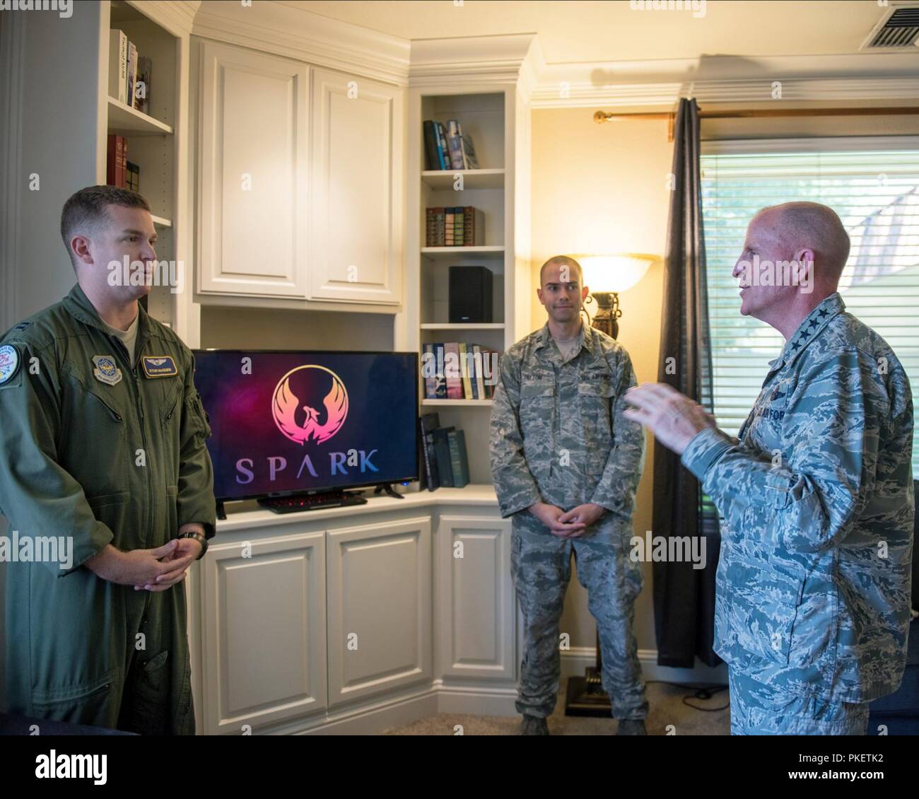 U.S. Air Force Vice Chief of Staff Gen. Stephen Wilson, right, speaks with Capt. Ryan McGuire and Capt. Jacob Payton, both with the 60th Air Mobility Wing Phoenix Spark program, about the base's innovation initiatives during a visit at Travis Air Force Base, Calif., July 25, 2018. Wilson stopped at Travis for a gas-and-go before flying to Joint Base Pearl Harbor-Hickam, Hi., to attend the Commander of Pacific Air Forces assumption of command ceremony. Stock Photo