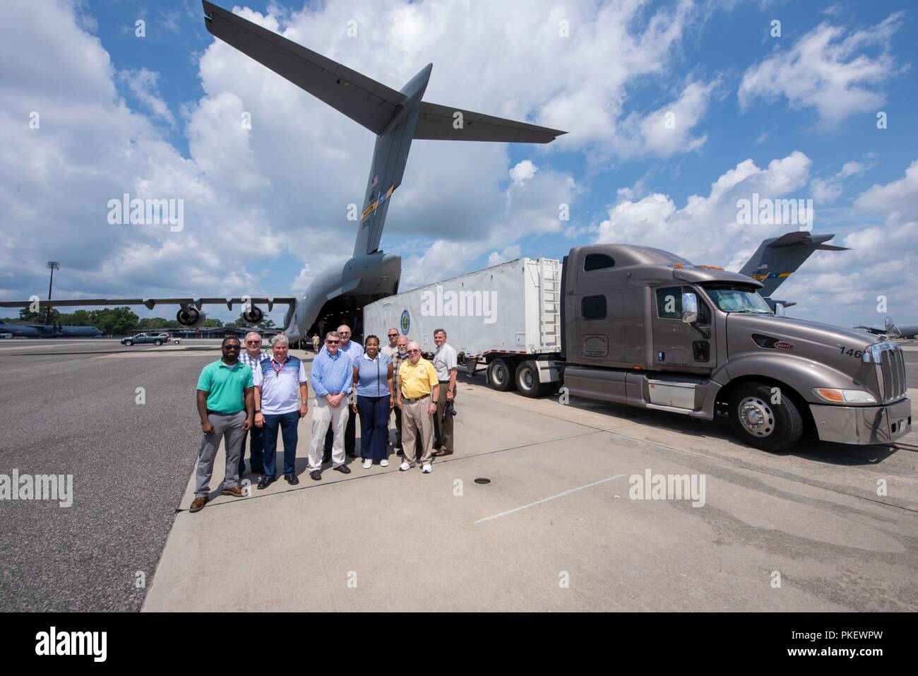 Charleston, S.C. (26 July, 2018) Space and Naval Warfare Systems Center (SSC) Atlantic engineers and officials from the Federal Aviation Administration pause for a photo following a test load of a Large Mobile Air Traffic Control Tower (LMATCT) onto a C-17 Globemaster III July 26 at the Joint Base Charleston - Air Base. The test load was conducted in coordination with the 437th Aerial Port Squadron to validate the Air Transportability Test Loading Activity certification and ensure the newly constructed towers were compatible for airlift aboard U.S. Air Force aircraft. Stock Photo