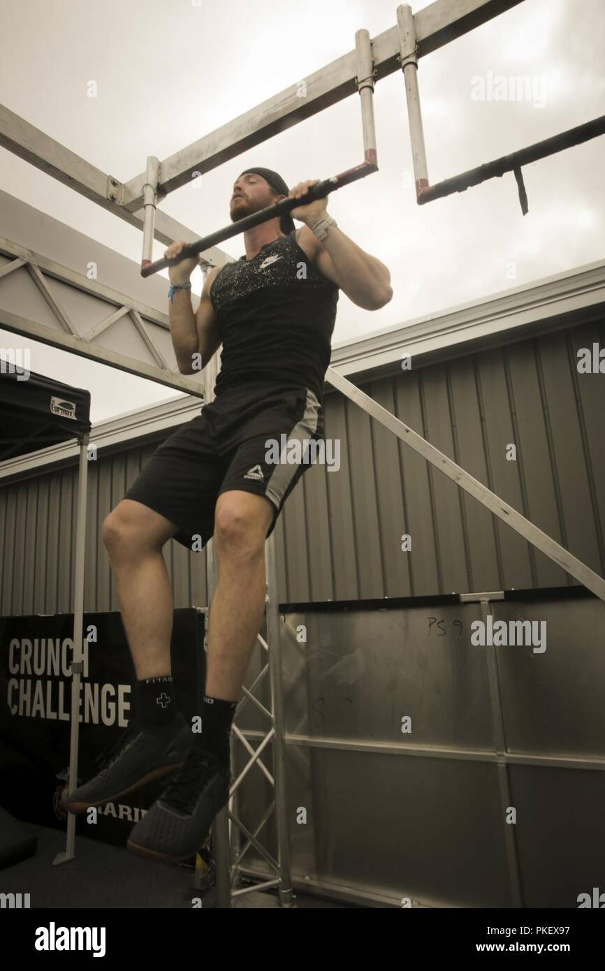 MADISON, Wisconsin – Dave Miner, a native of Homer, New York, executes a  dead hang pull-up at the Marine Corps Battles Won Challenge trailer during  the 2018 Reebok CrossFit Games at the